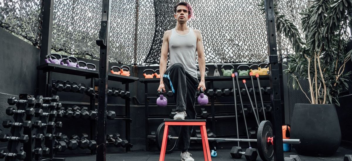 Adult male performing kettlebell exercises in a modern Mexico City gym.